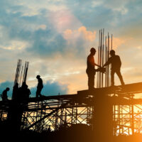 Silhouette of engineer and construction team working at site ove